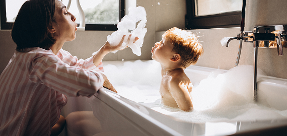 Mother giving child a bubble bath